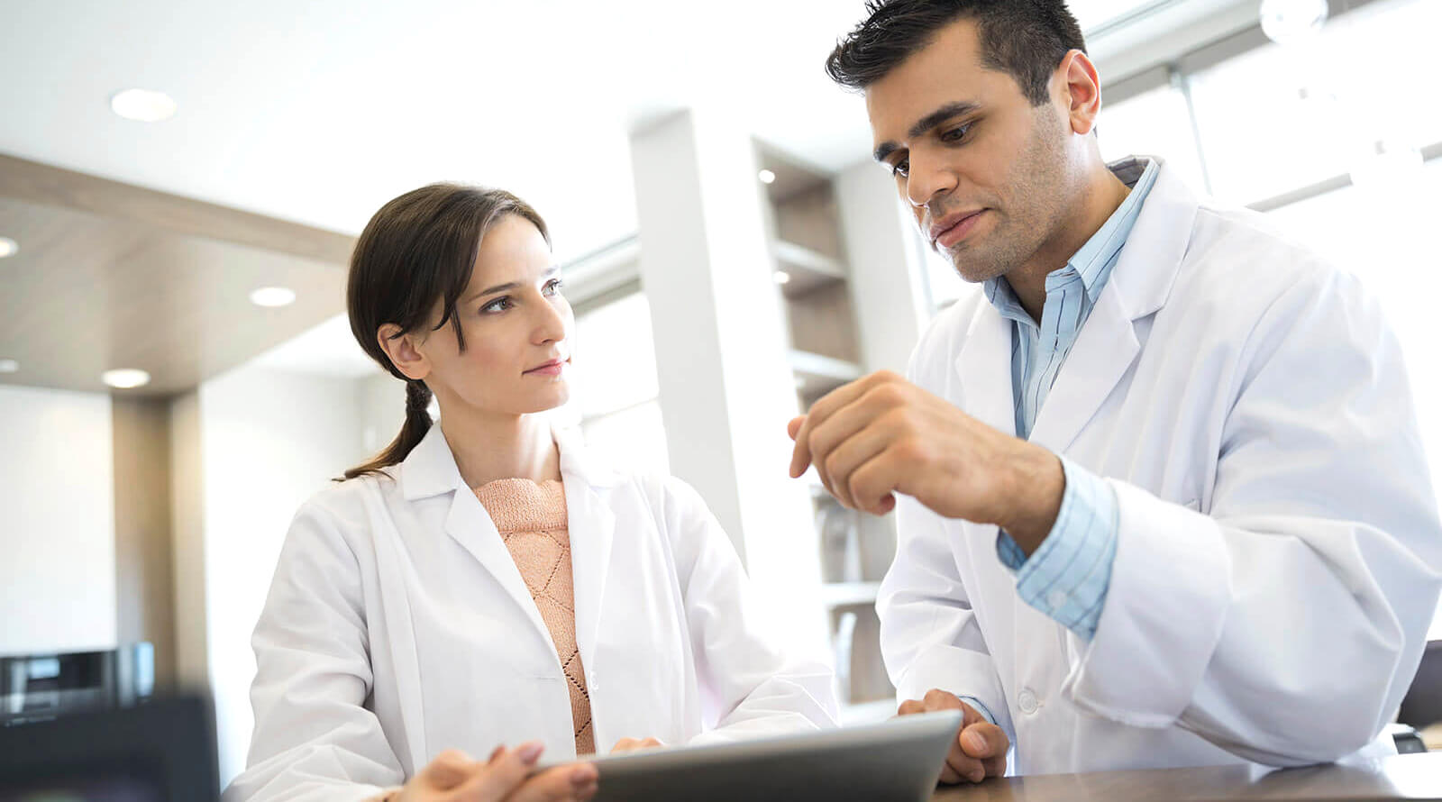 GettyImages-490634985-cropped a male and female dentist talking to one another